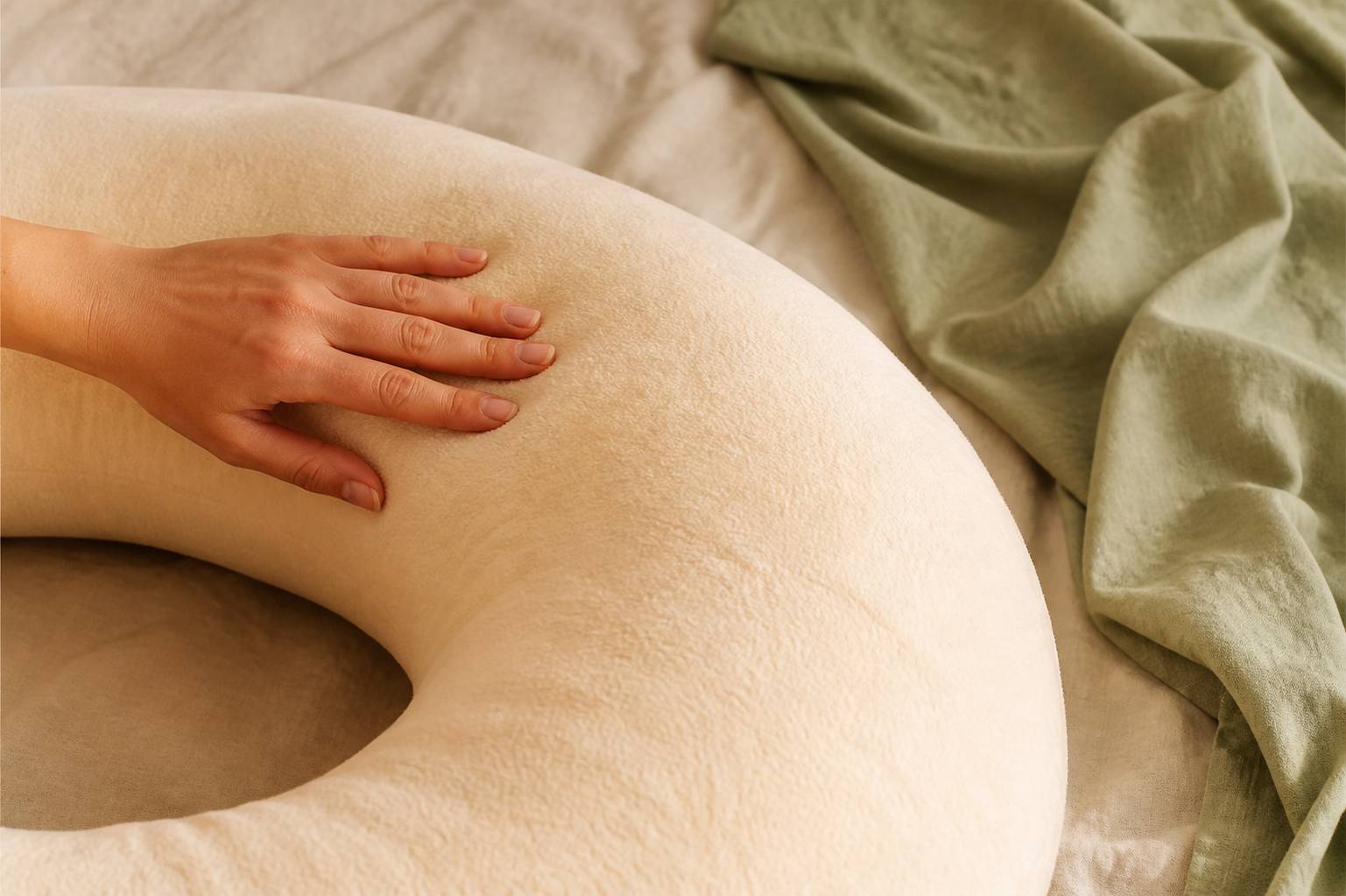 Main sur le tissu doux d'un coussin de grossesse